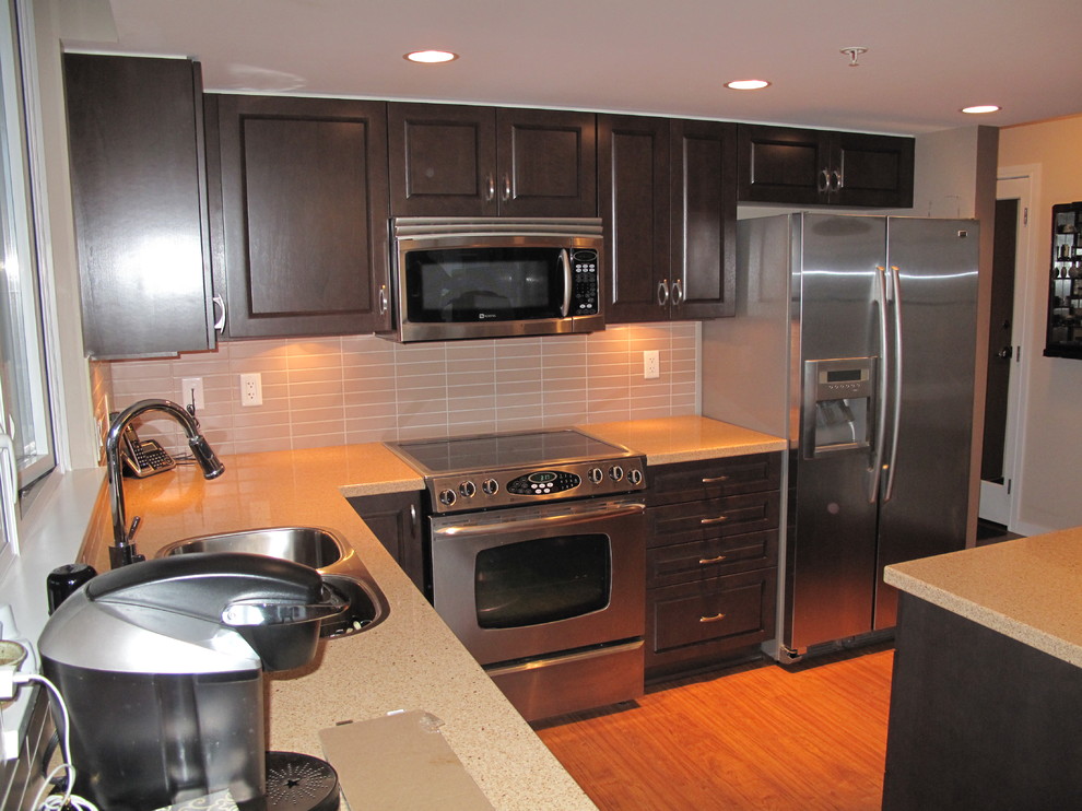 Mid-sized modern l-shaped eat-in kitchen in Vancouver with raised-panel cabinets, medium wood cabinets, stainless steel appliances and with island.