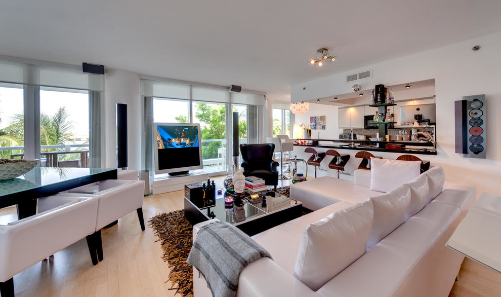 Photo of a large modern open concept living room in Miami with a music area, white walls, light hardwood floors, no fireplace and a freestanding tv.