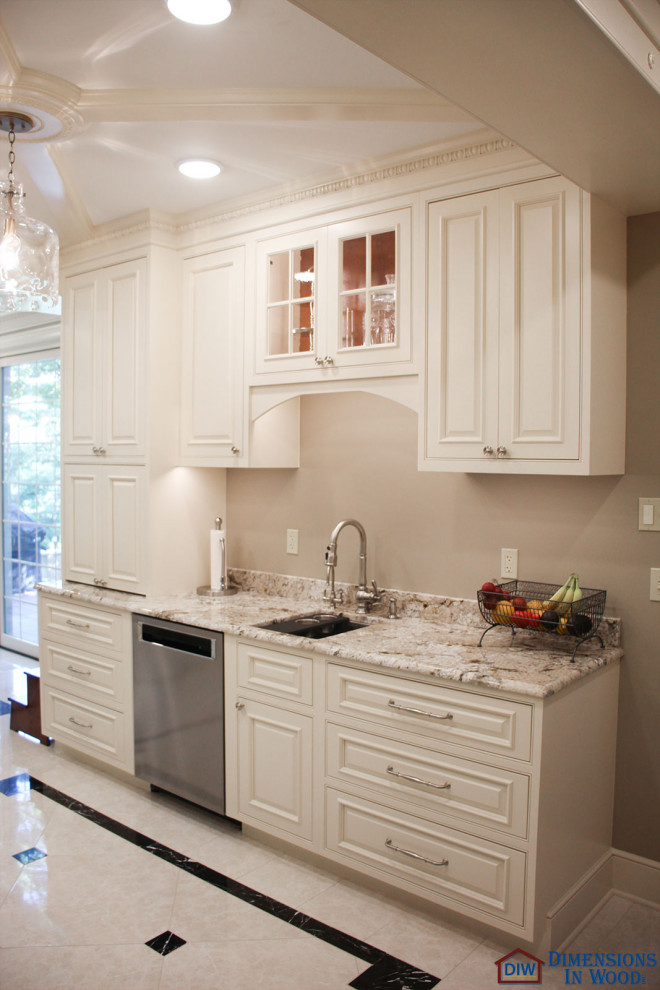 Exempel på ett stort klassiskt beige beige kök, med en enkel diskho, vita skåp, granitbänkskiva, vitt stänkskydd, stänkskydd i keramik, rostfria vitvaror, klinkergolv i keramik, en köksö och vitt golv