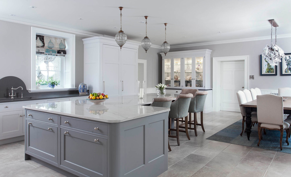 Design ideas for an expansive traditional l-shaped open plan kitchen in Other with an integrated sink, shaker cabinets, grey cabinets, marble benchtops, white splashback, ceramic splashback, black appliances, ceramic floors, with island and grey floor.