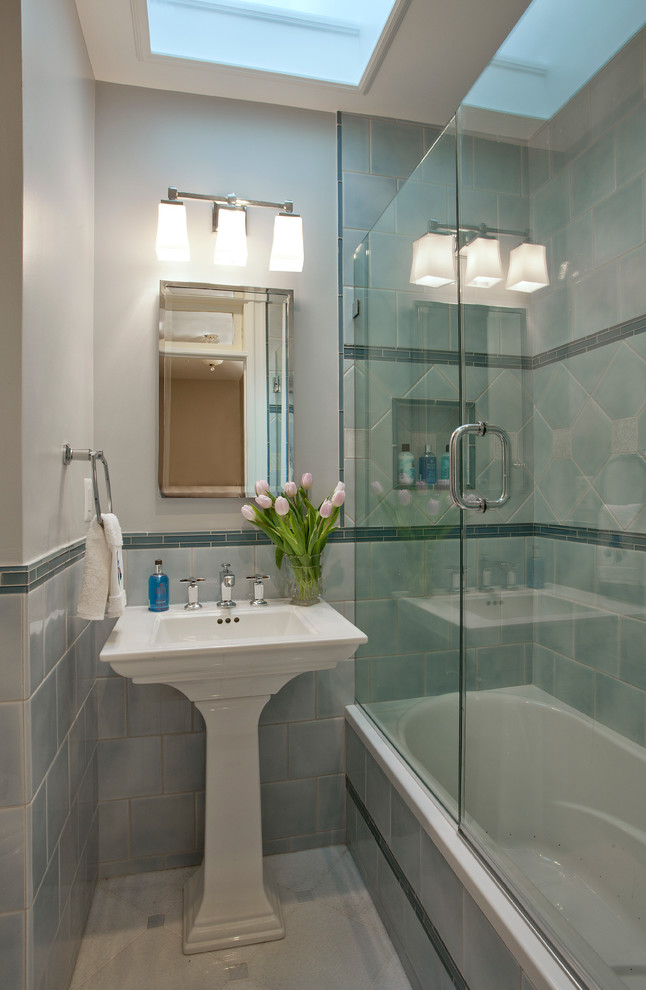 Photo of a small traditional bathroom in DC Metro with a pedestal sink, an alcove tub, a shower/bathtub combo, blue tile, porcelain tile, marble floors and grey walls.