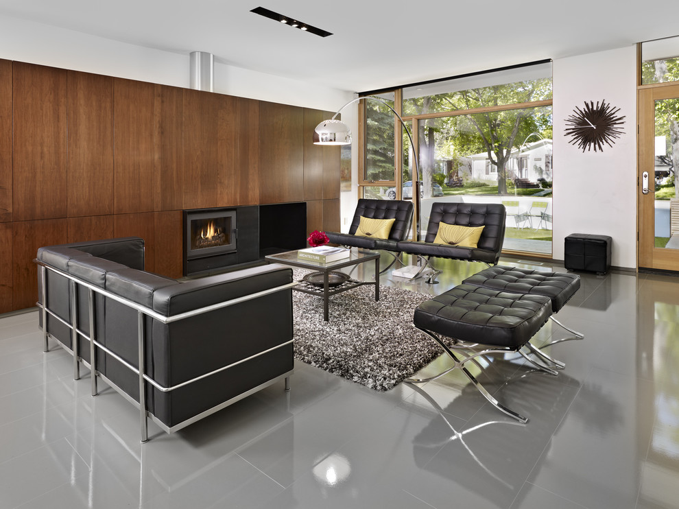 This is an example of a modern living room in Edmonton with white walls and a standard fireplace.