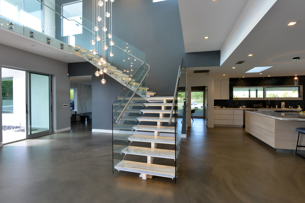 This is an example of a mid-sized modern marble l-shaped staircase in Los Angeles with open risers and metal railing.