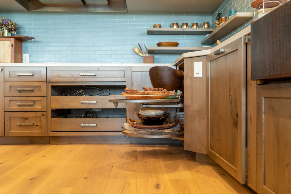 Inspiration for a transitional eat-in kitchen remodel in Phoenix with a farmhouse sink, shaker cabinets, medium tone wood cabinets, granite countertops, blue backsplash, subway tile backsplash, paneled appliances and an island