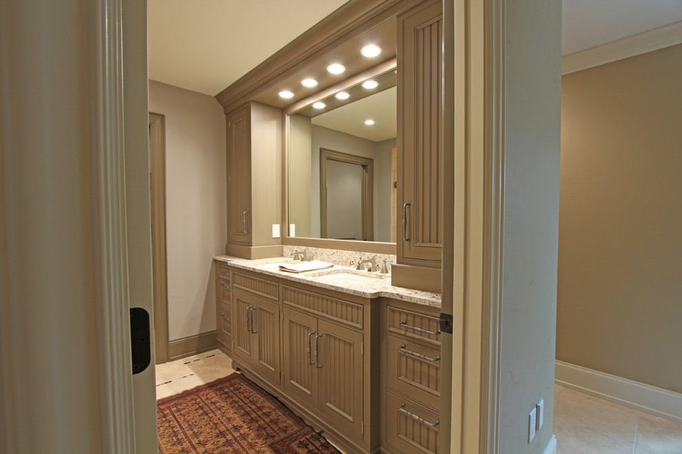 Inspiration for a large traditional master bathroom in Other with beaded inset cabinets, beige cabinets, an alcove shower, a two-piece toilet, gray tile, travertine, grey walls, travertine floors, an undermount sink, granite benchtops, beige floor and a hinged shower door.
