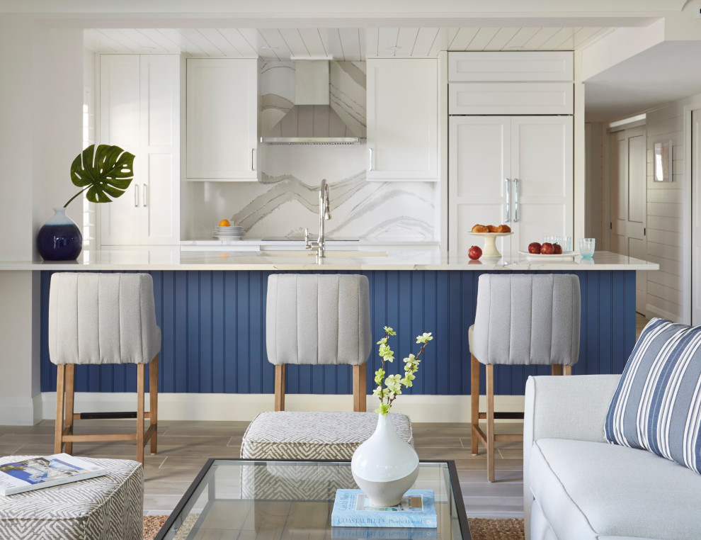 Design ideas for a mid-sized beach style galley open plan kitchen with an undermount sink, shaker cabinets, white cabinets, quartz benchtops, beige splashback, engineered quartz splashback, panelled appliances, porcelain floors, a peninsula, grey floor, beige benchtop and timber.