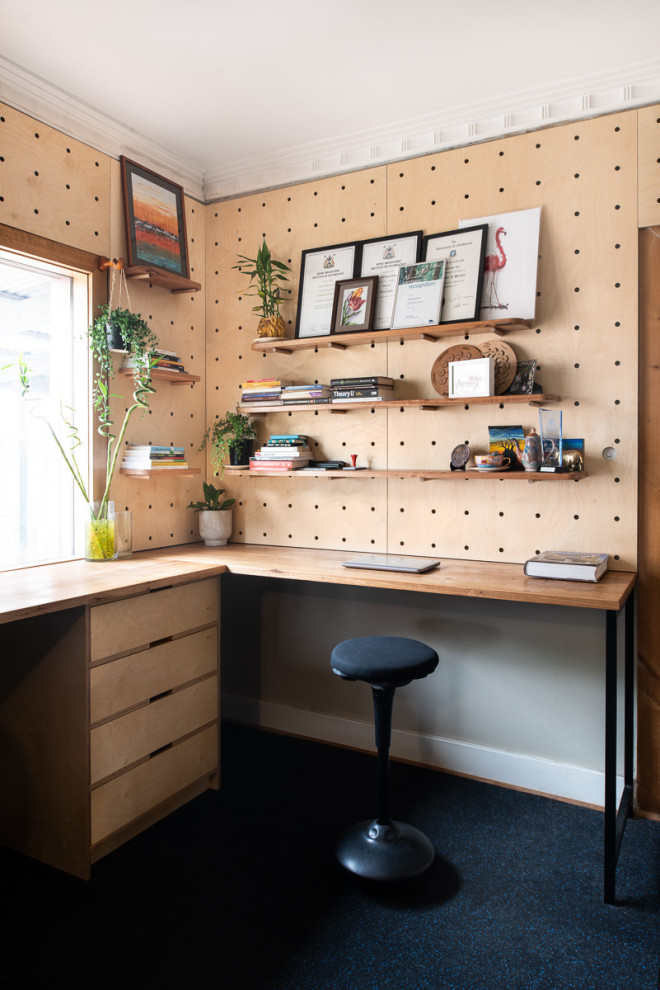 This is an example of a mid-sized contemporary home studio in Melbourne with cork floors and a built-in desk.