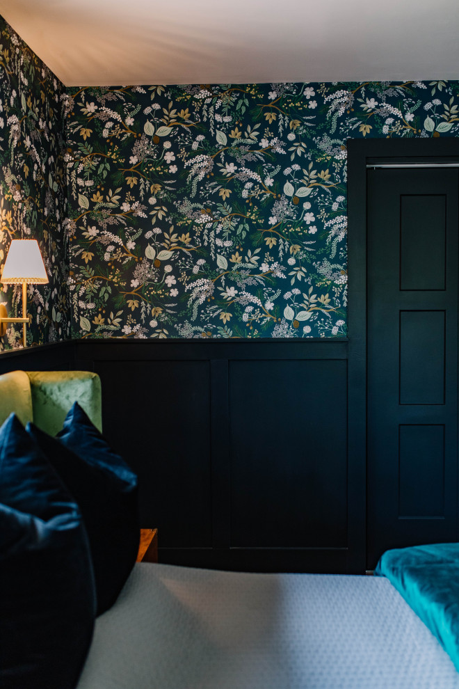 Immagine di una camera matrimoniale eclettica con pareti nere, pavimento in legno massello medio, pavimento marrone e carta da parati