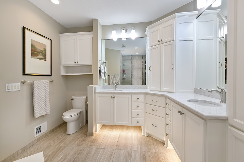 Design ideas for a large transitional 3/4 bathroom in Minneapolis with recessed-panel cabinets, white cabinets, a two-piece toilet, an undermount sink, an alcove shower, brown tile, porcelain tile, grey walls, porcelain floors, marble benchtops, beige floor, a hinged shower door and grey benchtops.