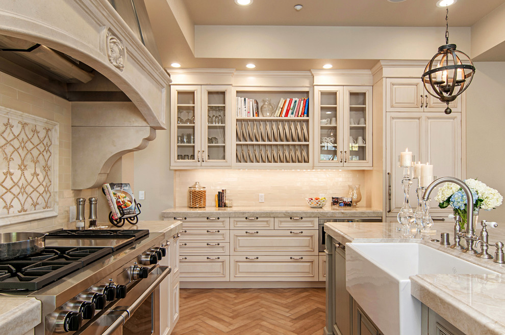 Design ideas for a traditional kitchen in San Diego with a farmhouse sink, raised-panel cabinets, beige splashback, stainless steel appliances, medium hardwood floors and with island.