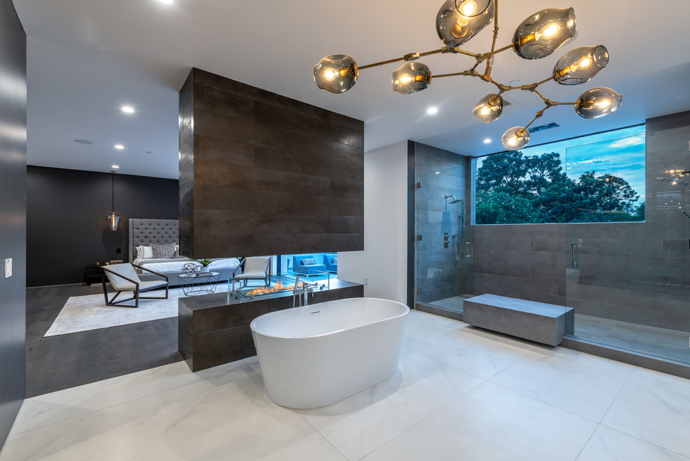 Photo of a contemporary master bathroom in Los Angeles with a freestanding tub, a double shower, gray tile and white floor.