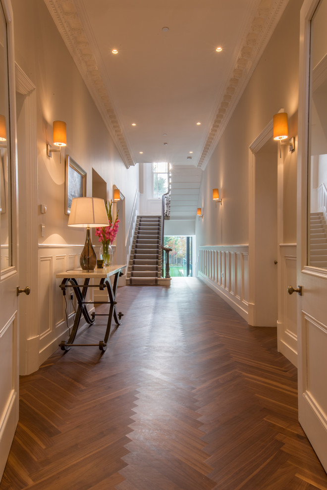 Large contemporary hallway in London with white walls and medium hardwood floors.