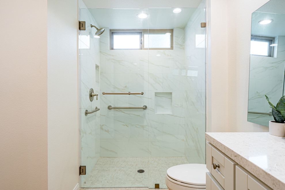 Photo of a medium sized contemporary shower room bathroom in Orange County with beaded cabinets, white cabinets, an alcove shower, a one-piece toilet, white tiles, marble tiles, white walls, light hardwood flooring, a built-in sink, limestone worktops, brown floors, a hinged door, white worktops, a single sink, a built in vanity unit, a coffered ceiling and wallpapered walls.