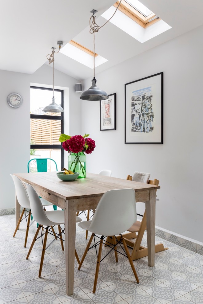 Inspiration for a mid-sized eclectic kitchen/dining combo in London with grey walls and ceramic floors.