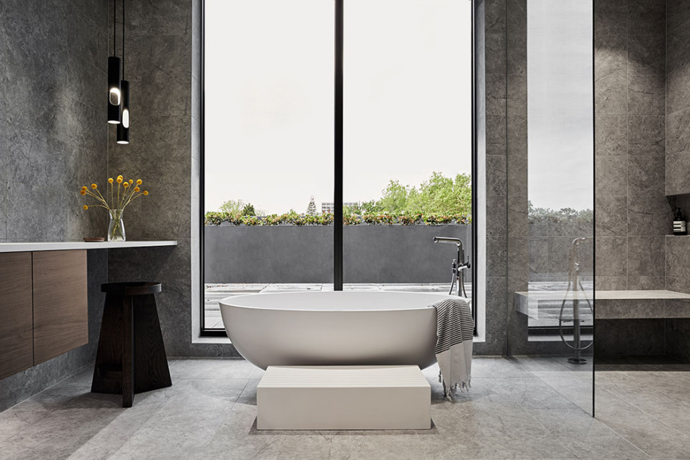 Ispirazione per una grande stanza da bagno minimal con vasca freestanding, piastrelle grigie, pavimento grigio e doccia aperta