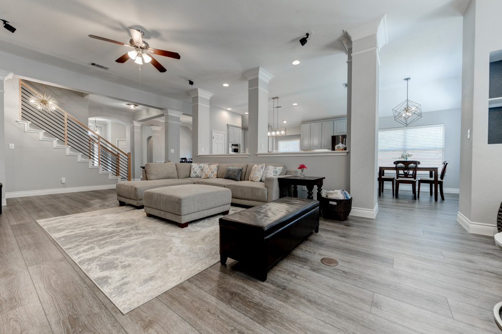 Mid-sized transitional formal open concept living room in Austin with vinyl floors, a standard fireplace, a tile fireplace surround, a freestanding tv, brown floor and vaulted.