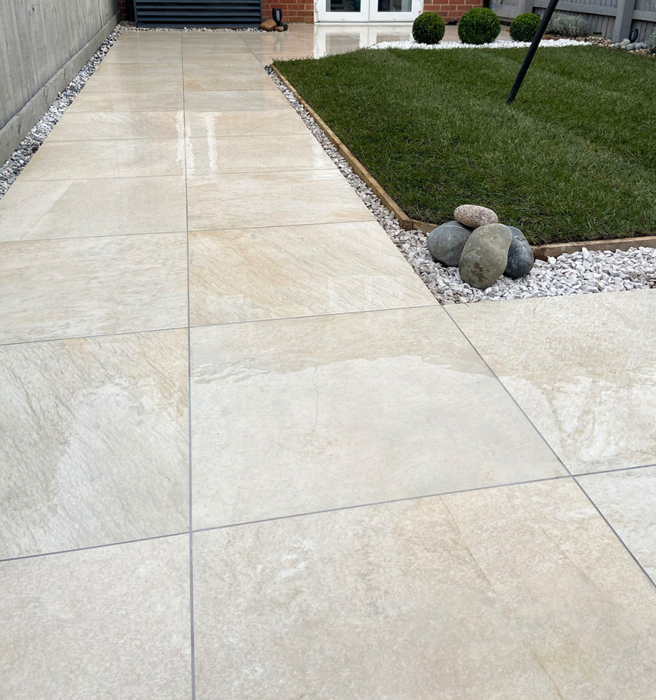 Mid-sized contemporary backyard patio in Hertfordshire with tile.