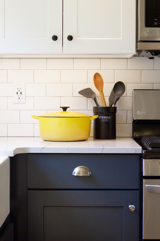 Eat-in kitchen - transitional eat-in kitchen idea with a farmhouse sink, shaker cabinets, blue cabinets, quartz countertops, white backsplash, subway tile backsplash, stainless steel appliances, an island and white countertops