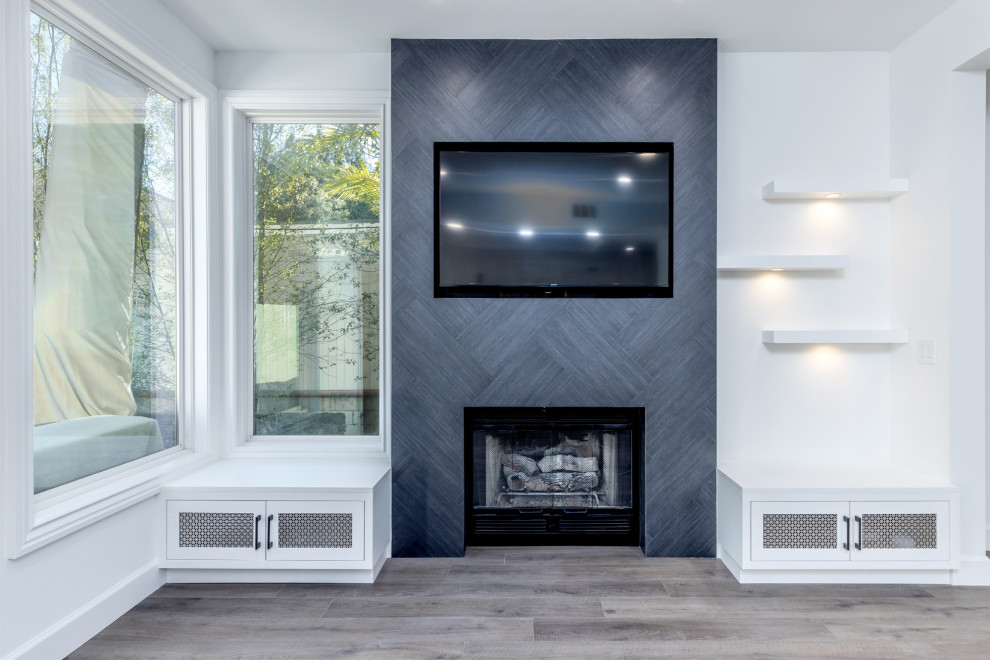This is an example of a mid-sized modern formal open concept living room in San Diego with white walls, vinyl floors, a standard fireplace, a tile fireplace surround, a built-in media wall and grey floor.