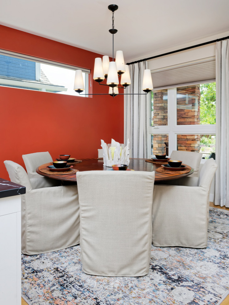 Foto di una sala da pranzo aperta verso la cucina minimal di medie dimensioni con pareti multicolore, pavimento in legno massello medio e nessun camino