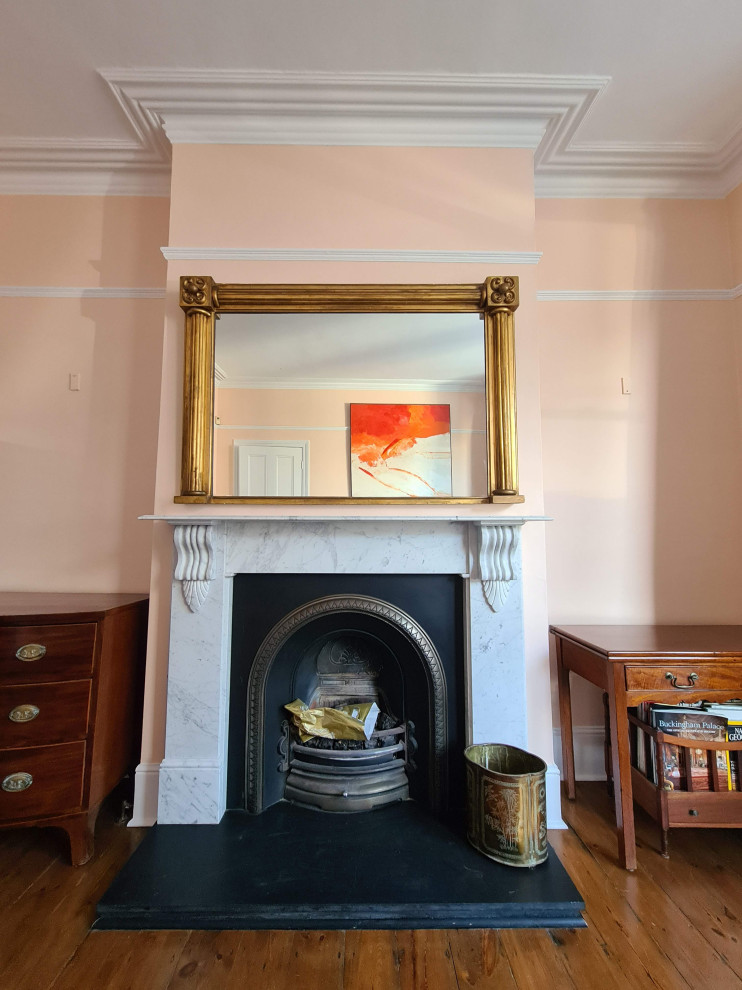 Aménagement d'une grande salle à manger ouverte sur le salon classique avec un mur orange, parquet foncé, une cheminée standard, un manteau de cheminée en métal, un sol marron et un plafond décaissé.