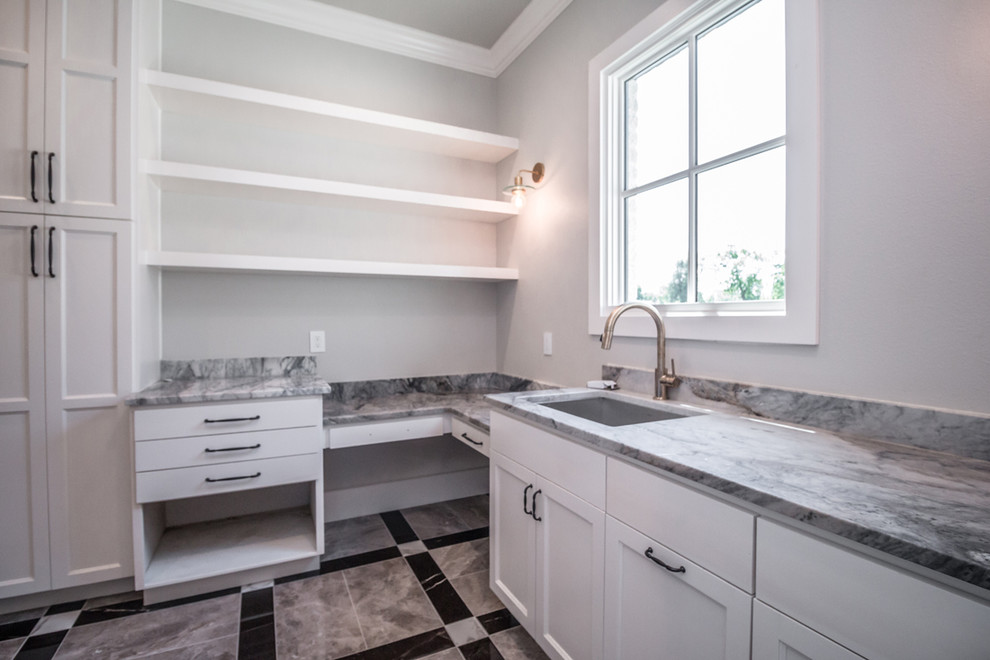 This is an example of a large transitional l-shaped dedicated laundry room in Other with an undermount sink, recessed-panel cabinets, white cabinets, granite benchtops, grey walls, porcelain floors, a side-by-side washer and dryer, multi-coloured floor and multi-coloured benchtop.