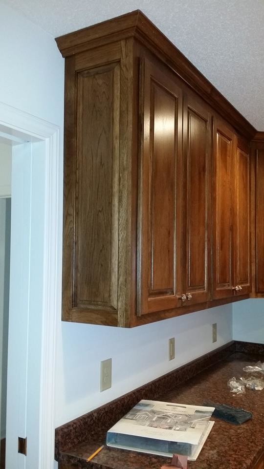 This is an example of a large traditional l-shaped eat-in kitchen in Raleigh with a drop-in sink, raised-panel cabinets, brown cabinets, laminate benchtops, stainless steel appliances, medium hardwood floors and no island.