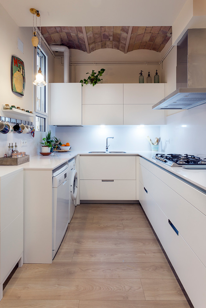 Modelo de cocina mediterránea de tamaño medio sin isla con fregadero de doble seno, suelo de madera en tonos medios, armarios con paneles lisos, puertas de armario blancas, salpicadero blanco y electrodomésticos blancos