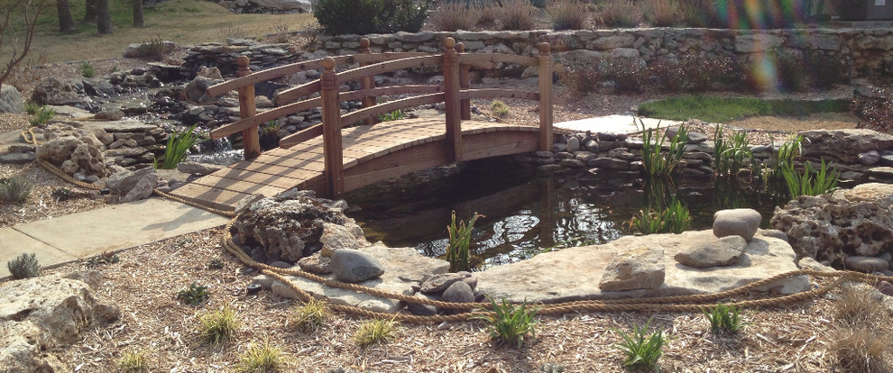 Photo of a mid-sized rustic partial sun backyard stone formal garden.