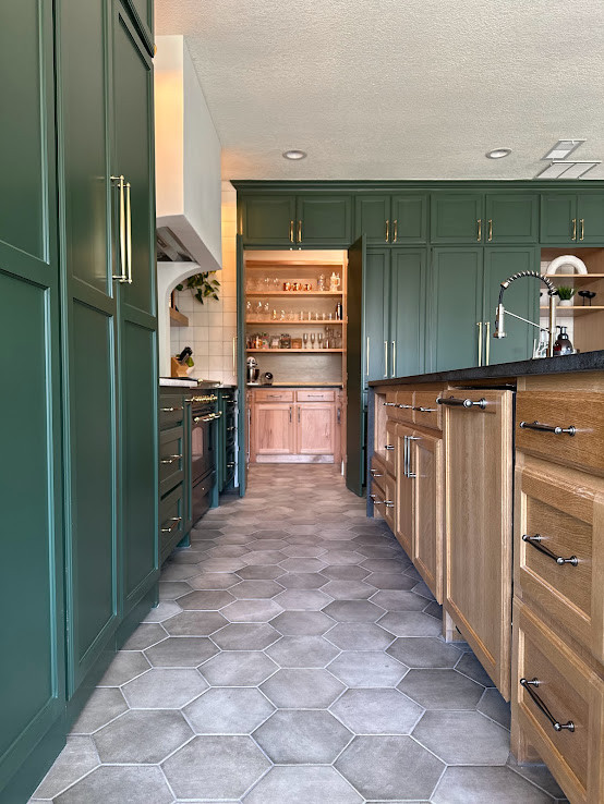 ダラスにある高級な広いトランジショナルスタイルのおしゃれなキッチン (シングルシンク、シェーカースタイル扉のキャビネット、緑のキャビネット、珪岩カウンター、白いキッチンパネル、セラミックタイルのキッチンパネル、パネルと同色の調理設備、磁器タイルの床、グレーの床、黒いキッチンカウンター) の写真