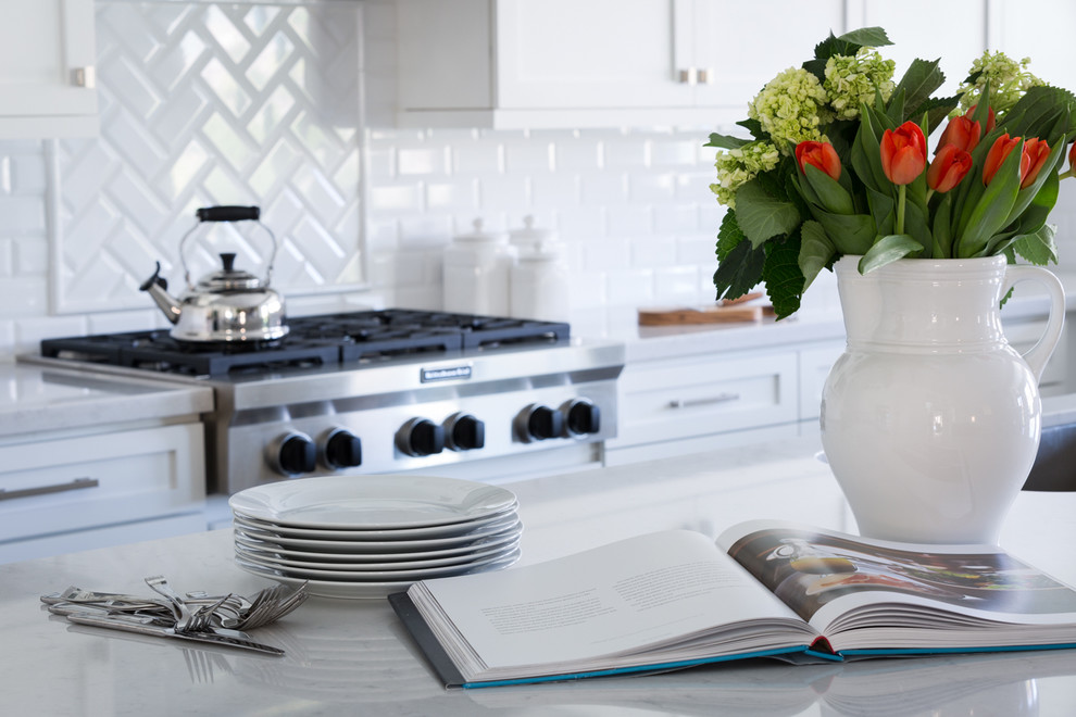 Example of a large transitional l-shaped medium tone wood floor open concept kitchen design in Phoenix with shaker cabinets, white cabinets, quartz countertops, white backsplash, subway tile backsplash, stainless steel appliances and an island