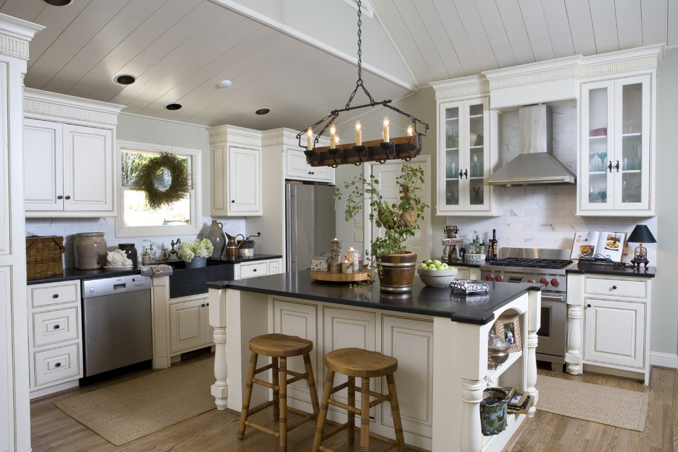 Traditional kitchen in Atlanta with beaded inset cabinets, a farmhouse sink, white cabinets, white splashback, stone tile splashback and stainless steel appliances.
