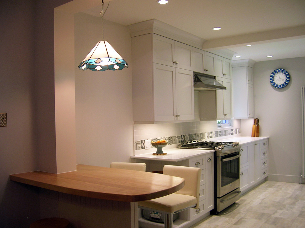 Photo of a small scandinavian galley eat-in kitchen in Montreal with a single-bowl sink, shaker cabinets, white cabinets, quartzite benchtops, white splashback, ceramic splashback, stainless steel appliances, porcelain floors and no island.