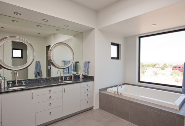 This is an example of a mid-sized contemporary master bathroom in Albuquerque with flat-panel cabinets, white cabinets, an alcove tub, white walls, ceramic floors and an undermount sink.