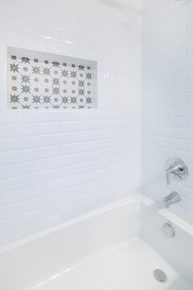 Inredning av ett lantligt litet vit vitt en-suite badrum, med skåp i shakerstil, vita skåp, ett undermonterat badkar, en dusch/badkar-kombination, en toalettstol med hel cisternkåpa, vit kakel, keramikplattor, blå väggar, klinkergolv i keramik, ett integrerad handfat, bänkskiva i akrylsten, flerfärgat golv och dusch med duschdraperi