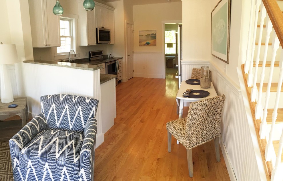 Example of a mid-sized beach style l-shaped medium tone wood floor open concept kitchen design in Boston with an undermount sink, shaker cabinets, white cabinets, granite countertops, stainless steel appliances and no island