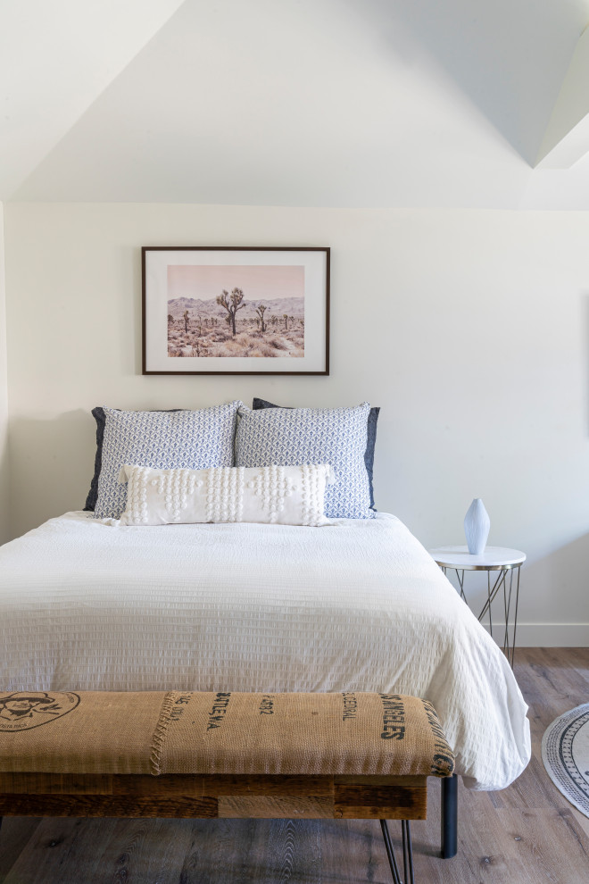 Photo of a small transitional loft-style bedroom in Los Angeles with beige walls, vinyl floors, brown floor and vaulted.