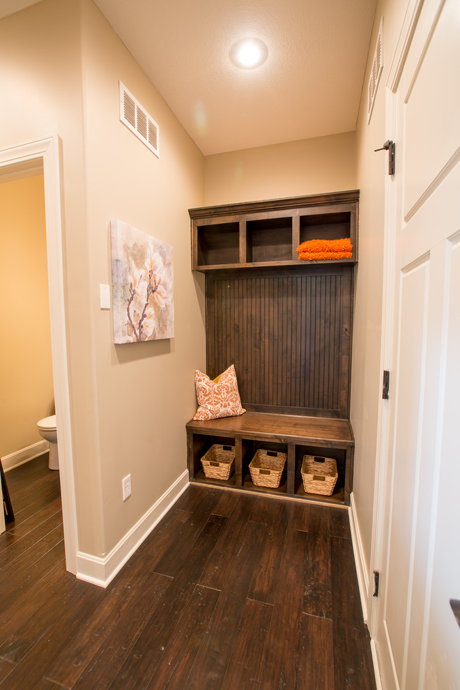 Photo of a mid-sized arts and crafts mudroom in Kansas City with beige walls, dark hardwood floors and a white front door.