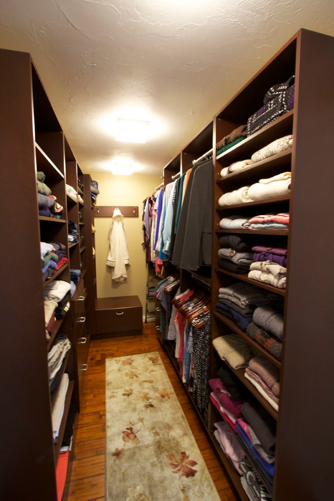 Example of a large transitional women's medium tone wood floor walk-in closet design in Boston with flat-panel cabinets and dark wood cabinets