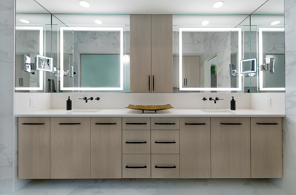 This is an example of an expansive modern master bathroom in Grand Rapids with flat-panel cabinets, light wood cabinets, white tile, marble, white walls, marble floors, an undermount sink, quartzite benchtops, white floor, a freestanding tub, an alcove shower, white benchtops and a sliding shower screen.