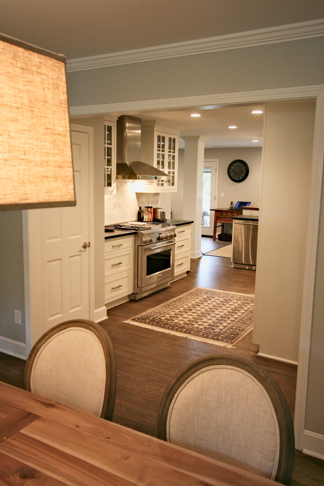 Inspiration for a mid-sized l-shaped dark wood floor kitchen remodel in Cincinnati with a farmhouse sink, flat-panel cabinets, white cabinets, soapstone countertops, stainless steel appliances and a peninsula