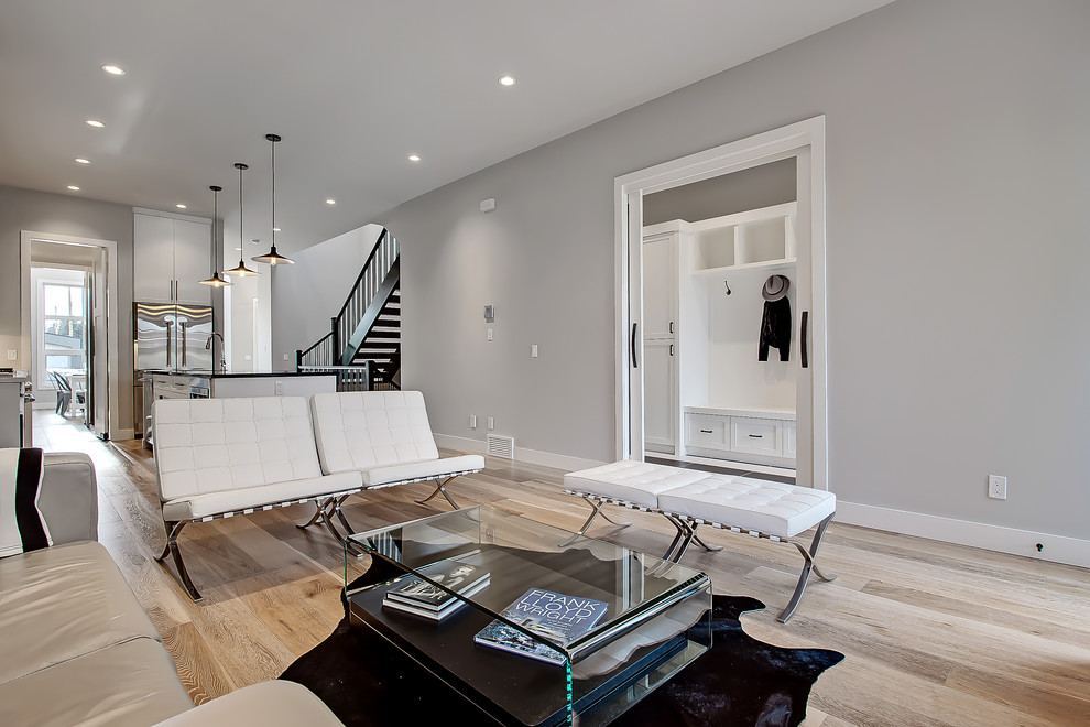 Design ideas for a transitional open concept living room in Calgary with grey walls and light hardwood floors.