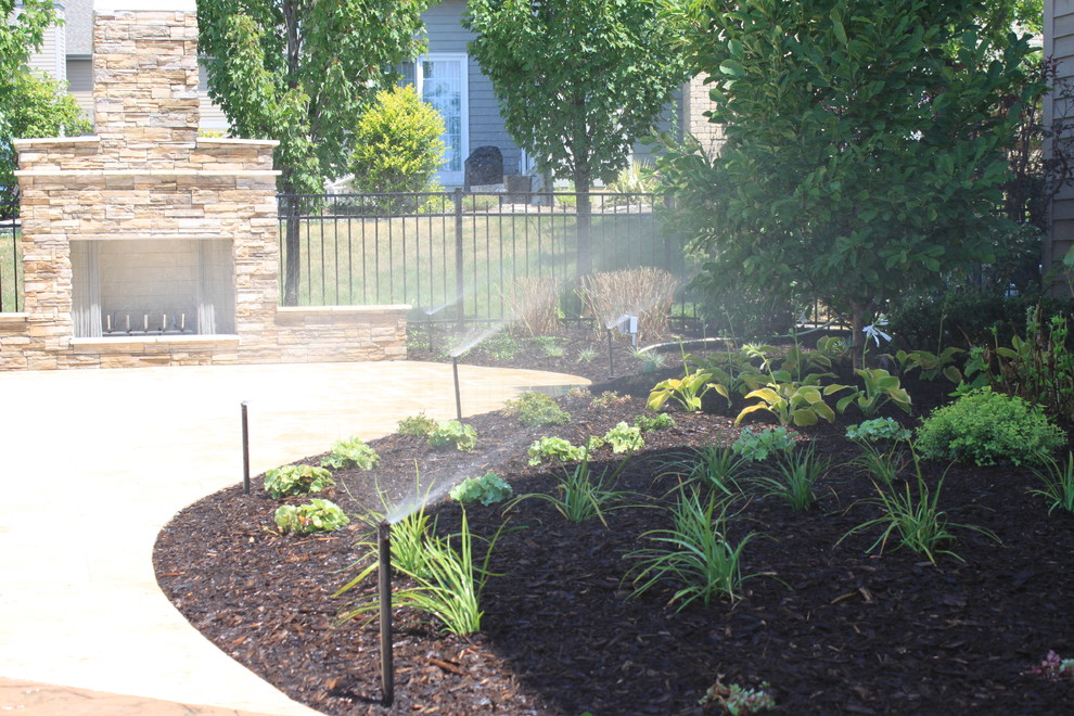 Design ideas for a mid-sized transitional full sun backyard stone landscaping in Chicago for spring.