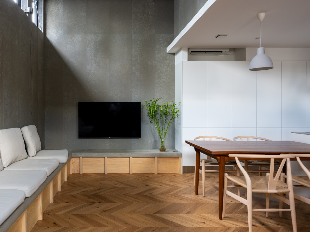 Inredning av ett skandinaviskt litet allrum med öppen planlösning, med en väggmonterad TV, brunt golv, en hemmabar, grå väggar och målat trägolv