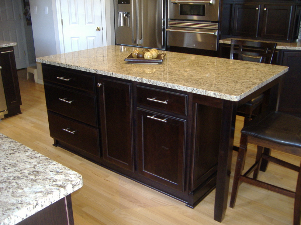 Eat-in kitchen - transitional u-shaped eat-in kitchen idea in Indianapolis with an undermount sink, flat-panel cabinets, dark wood cabinets, granite countertops and stainless steel appliances