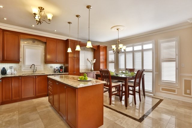 Large galley marble floor eat-in kitchen photo in Toronto with beaded inset cabinets, medium tone wood cabinets, granite countertops, beige backsplash, stone tile backsplash and an island
