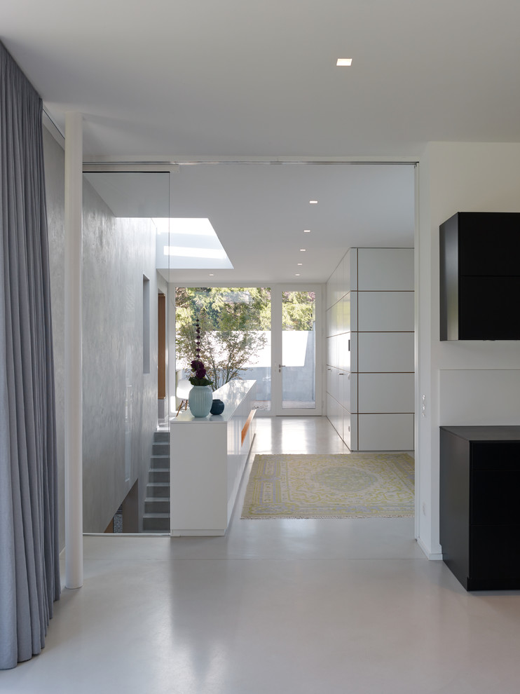 Großer Moderner Eingang mit Vestibül, weißer Wandfarbe, Einzeltür, weißem Boden und Terrazzo-Boden in Sonstige