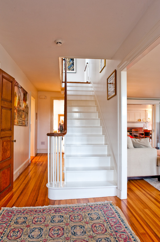 Photo of a traditional painted wood staircase in Boston with painted wood risers and wood railing.