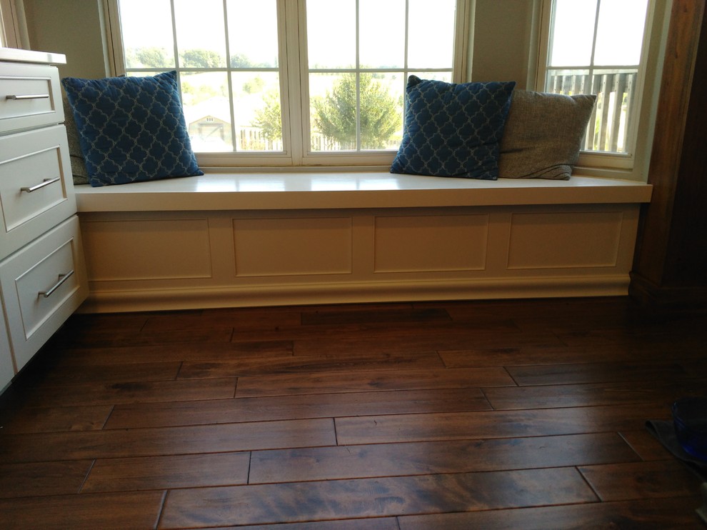 Mid-sized transitional l-shaped dark wood floor and brown floor eat-in kitchen photo with a single-bowl sink, shaker cabinets, white cabinets, quartzite countertops, gray backsplash, ceramic backsplash, stainless steel appliances and an island