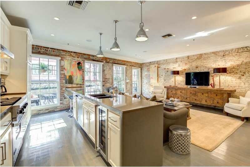 Inspiration for a mid-sized contemporary galley open plan kitchen in New Orleans with an undermount sink, recessed-panel cabinets, white cabinets, stainless steel appliances, painted wood floors and with island.